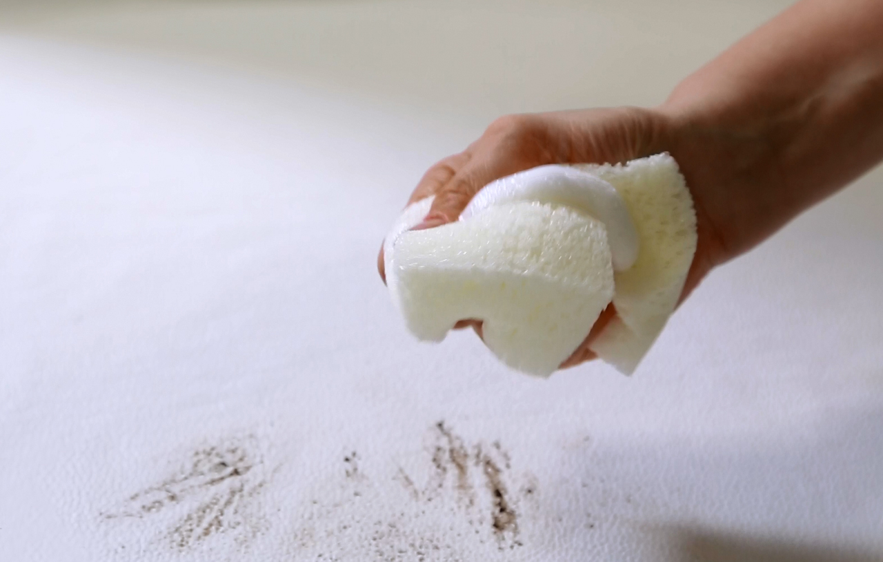 Lederreinigung Vorher – Hartnäckiger Schmutz auf Glattleder-Polstern. Tiefsitzende Verschmutzungen und Flecken auf einer Glattlederoberfläche vor der Behandlung mit KERALUX Intensivreiniger.